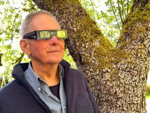 Robert Bateman looking at the sun with special solar eclipse glasses