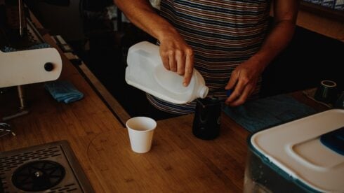 A woman pouring bleach into a cup