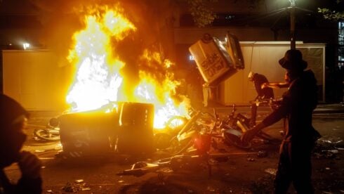 A bin is thrown into a fire in Barcelona during a Blocus riot